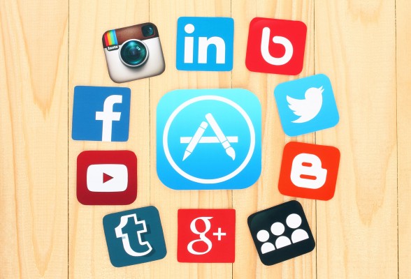 45701275 - kiev, ukraine - july 01, 2015: around appstore icon are placed famous social media icons such as: facebook, twitter, blogger, linkedin and others, printed on paper and placed on wooden background.